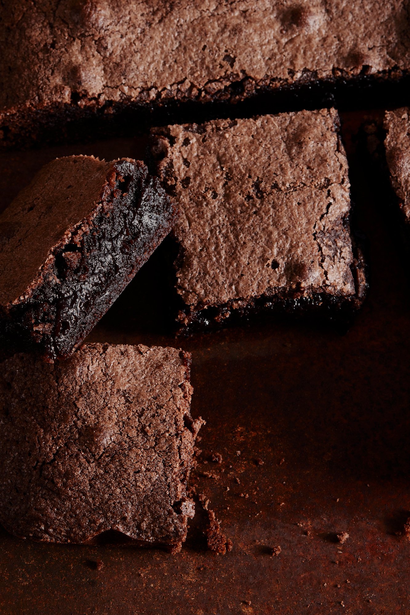 Cut brownies stacked close to the lens, their dense centres showing, Chocolate by Hannah Caldwell
