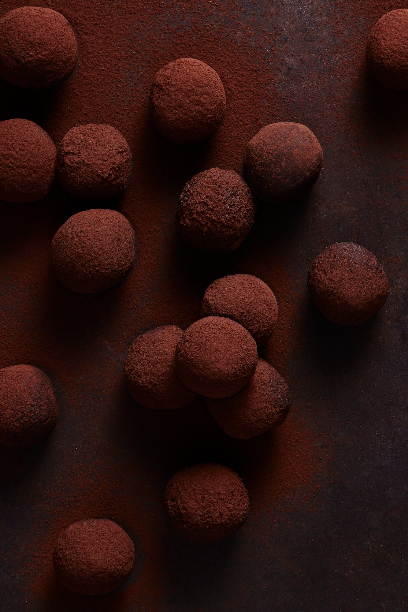 Chocolate truffles scattered loosely over a cocoa dusted surface, Chocolate by Hannah Caldwell